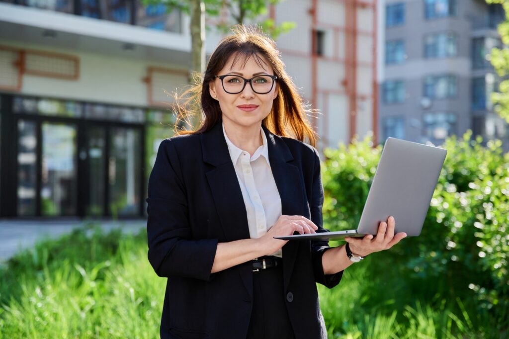 Portrait confident business successful mature woman, outdoors, urban background