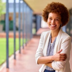 Portrait Of Smiling Female Elementary School Teacher Outdoors At School