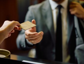 Close up of businessman receiving membership card at gym's reception desk.